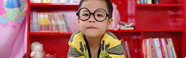 Young boy reading with glasses on
